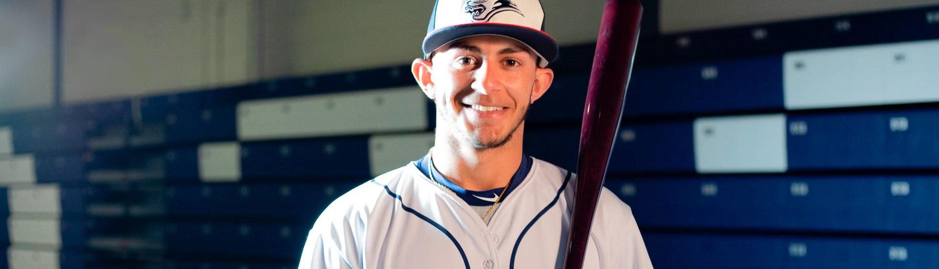 cougar's baseball player smiling with bat